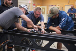 Technicians performing hands-on training on RV chassis systems, learning troubleshooting and repair techniques at NRVTA.